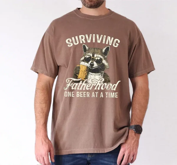 Surviving-Fatherhood-One-Beer-At-A-Time-2.webp Surviving Fatherhood One Beer At A Time, Funny Father Tee, Drinking Husband, Fathers Day Gift, Gift for Dad, Sarcastic Dad Grandpa T-Shirt